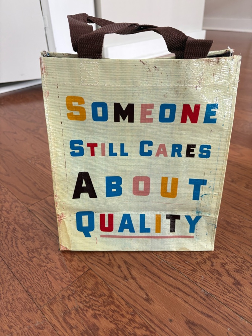 Reusable Tote Bag with Colorful 'Someone Still Cares About Quality' Text